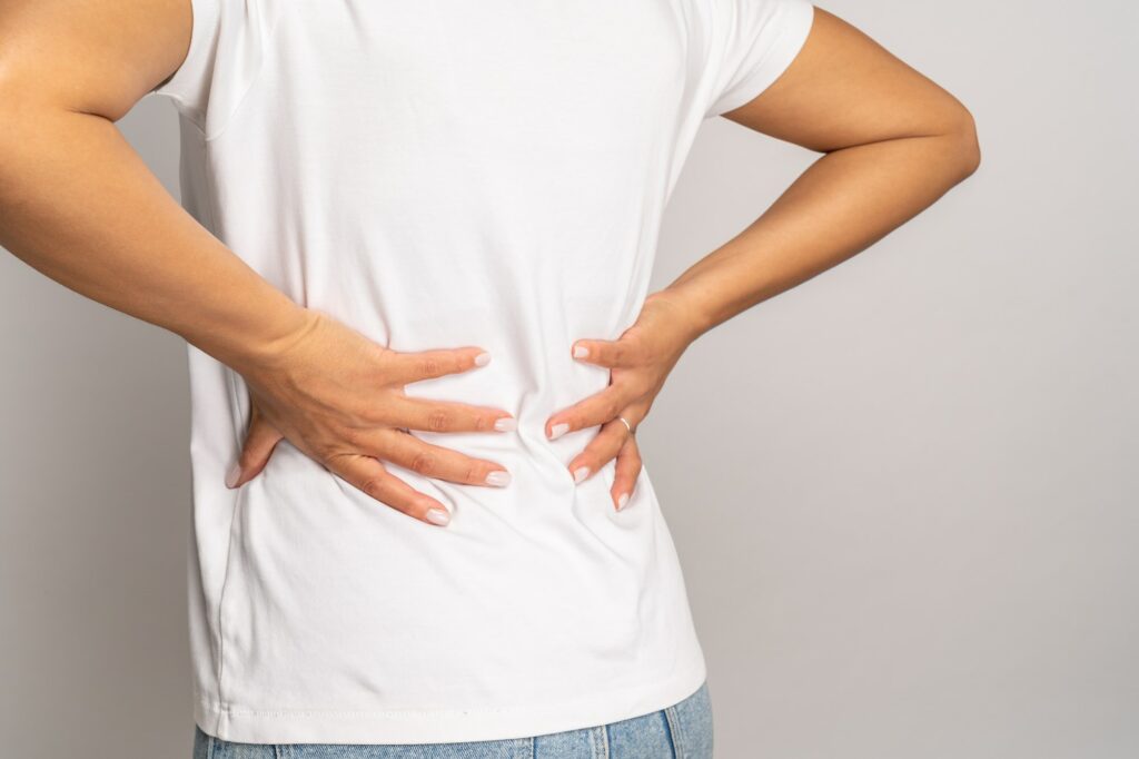 Female touching back suffer from backache. African woman with lower lumbar, spinal or kidney ache